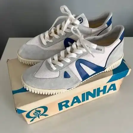 Par de tênis Rainha vintage branco, cinza e azul sobre a caixa original da marca