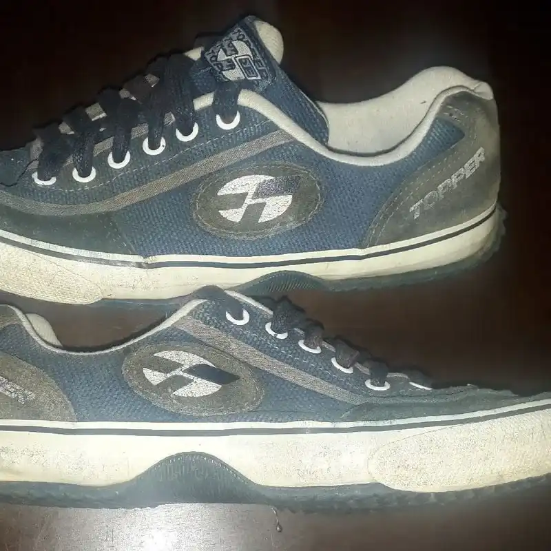 Par de tênis Topper vintage azul-marinho e cinza, com solado branco, sobre superfície escura